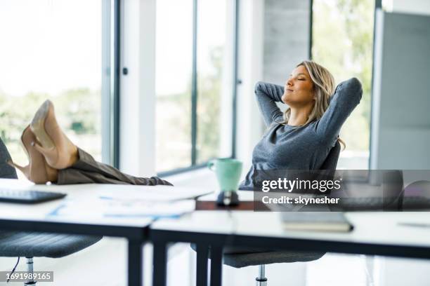 relaxed businesswoman having a break in the office. - feet on table bildbanksfoton och bilder