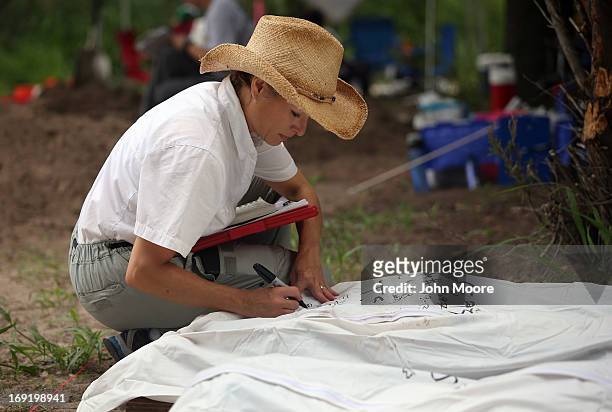 Forensic anthropologist Lori Baker from Baylor University marks a body bag after her team exhumed the remains of unidentified immigrants from a...
