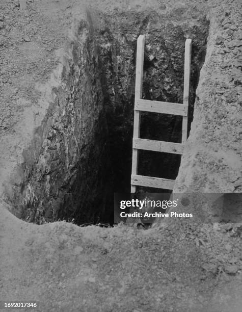 Man partially visible in the pit, beside a ladder, as excavations begin for the United States Bullion Depository, in the grounds of the United States...