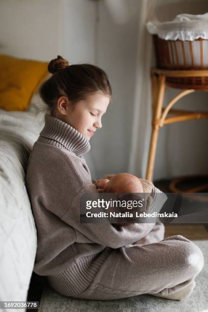 warm and snuggly: siblings in sweaters, big sister with little brother. - snuggly stock-fotos und bilder