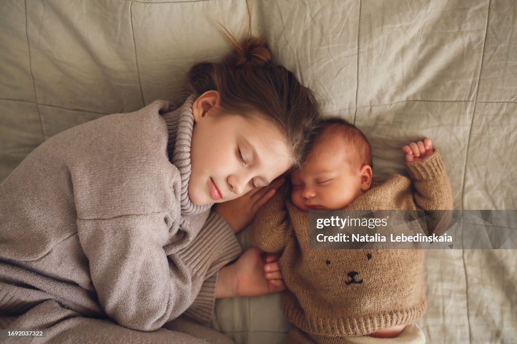 Sweet Dreams: Cozy Kids Siblings Slumber, Teenage Sister's Loving Touch to Baby in Knits