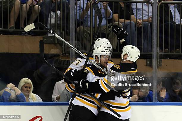 Daniel Paille of the Boston Bruins celebrates with teammates Dougie Hamilton and Shawn Thornton after scoring a goal in the third period to make the...