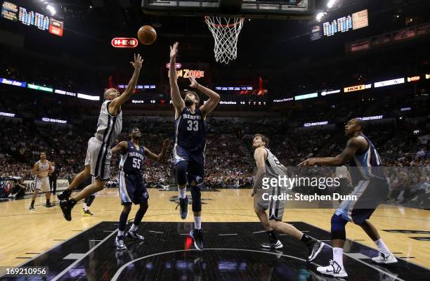 Tony Parker of the San Antonio Spurs drives for a shot attempt in the first half against Keyon Dooling and Marc Gasol of the Memphis Grizzlies during...