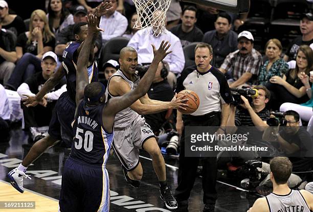 Tony Parker of the San Antonio Spurs looks to pass in the second half as he drives under the basket against Zach Randolph and Tony Allen of the...
