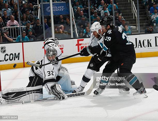 Logan Couture of the San Jose Sharks fires a shot against Jonathan Quick and Rob Scuderi of the Los Angeles Kings in Game Four of the Western...