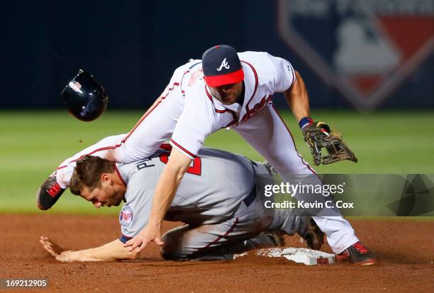 Dan Uggla of the Atlanta Braves attempts a double play ball as he collides into a sliding Trevor Plouffe of the Minnesota Twins in the 10th inning at...