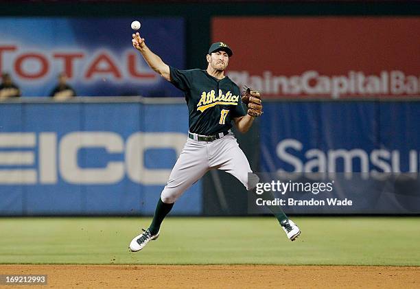 Adam Rosales of the Oakland Athletics throws to first to force out Craig Gentry of the Texas Rangers during the fifth inning of a baseball game at...