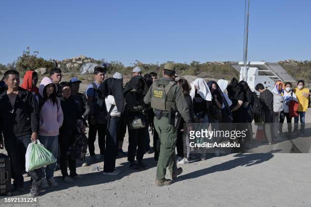 Group of asylum seekers arrive to a makeshift camp after crossing the nearby border with Mexico near the Jacumba Hot Springs desert, an...