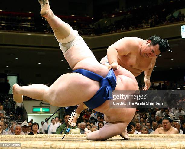 Ozeki Kotoshogiku throws Bulgarian sumo wrestler Aoiyama , whose real name is Daniel Ivanov to win during day ten of the Grand Sumo Summer Tournament...