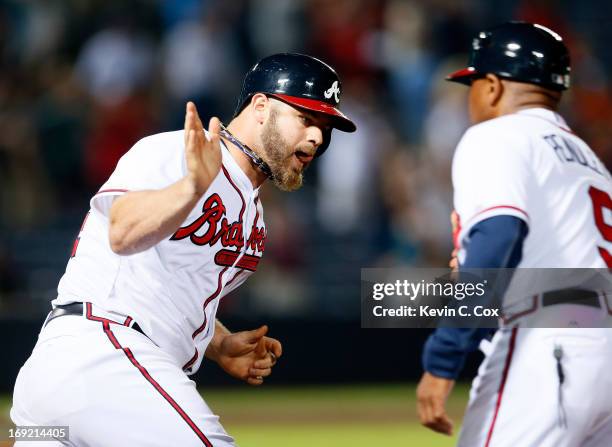 Evan Gattis of the Atlanta Braves celebrates his solo homer in the bottom of the ninth that tied the game 4-4 against the Minnesota Twins with first...