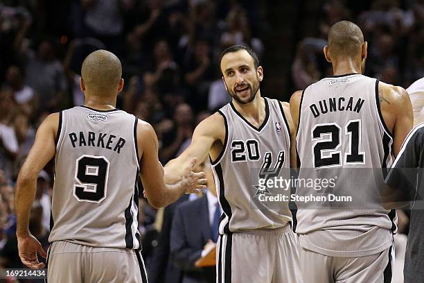 Tony Parker, Manu Ginobili and Tim Duncan of the San Antonio Spurs celebrate a play as they walk to the bench during a timeout in overtime against...