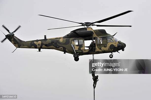 This picture taken on May 20, 2013 shows soldiers rappelling down from South Korean Army's new helicopter, Surion, during a rehearsal at a ceremony...