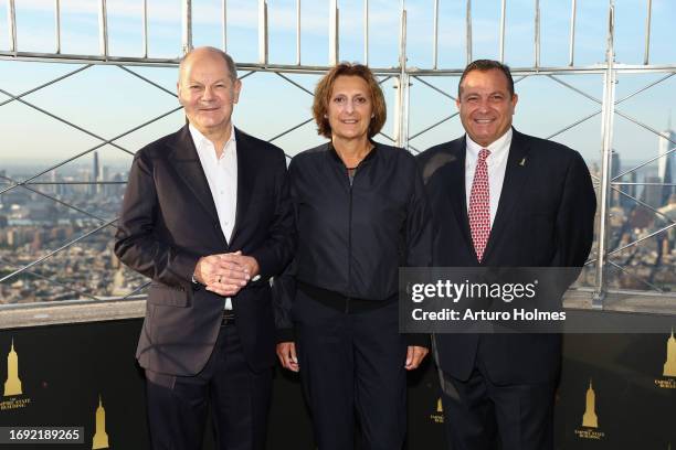 German Chancellor Olaf Scholz and Britta Ernst pose with Jean-Yves Ghazi as thevisit the Empire State Building Observatory at The Empire State...