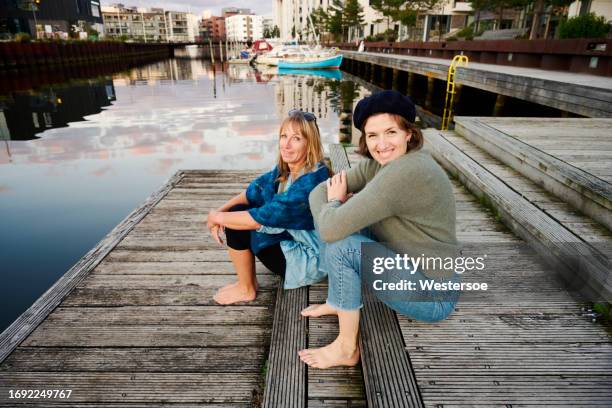 two adult women in conversation on pier - odense stockfoto's en -beelden