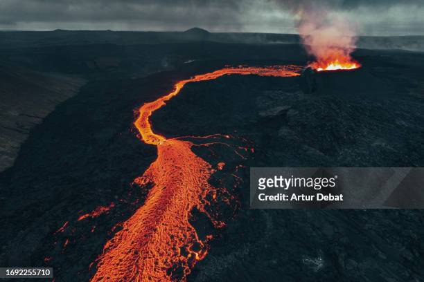 aerial view by drone of the dramatic volcano caldera expelling a river of lava in iceland. litli-hrutur 2023. - grindavik stock-fotos und bilder