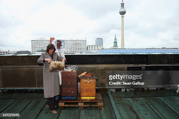 German Agriculture and Consumer Protection Minister Ilse Aigner holds a bees' honeycomb presented to her by beekeper Uwe Marth on the roof of the Dom...