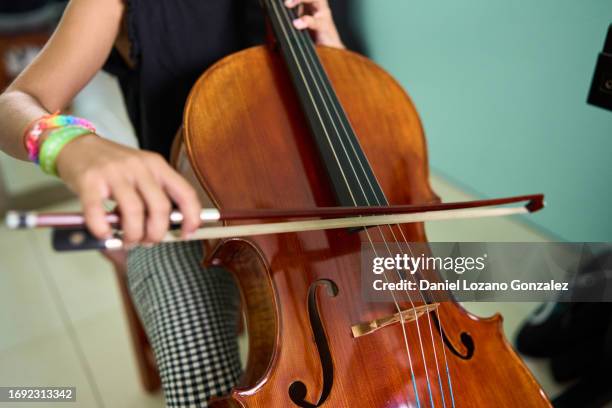 close-up of a girl playing cello at home - classical orchestral music stock pictures, royalty-free photos & images