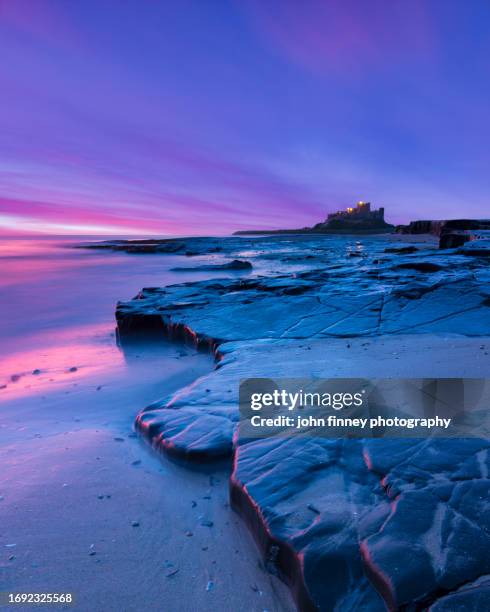 bamburgh castle from the beach at dawn with purple light - reflection pool stock pictures, royalty-free photos & images