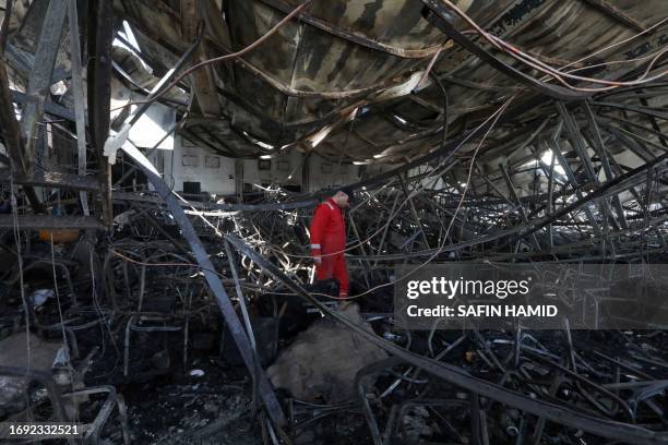 Firefighter checks the damage in an event hall in Qaraqosh, also known as Hamdaniyah, after a fire broke out during a wedding, killing at least 100...