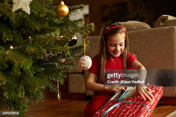 cute girl opening christmas present - before christmas foto e immagini stock
