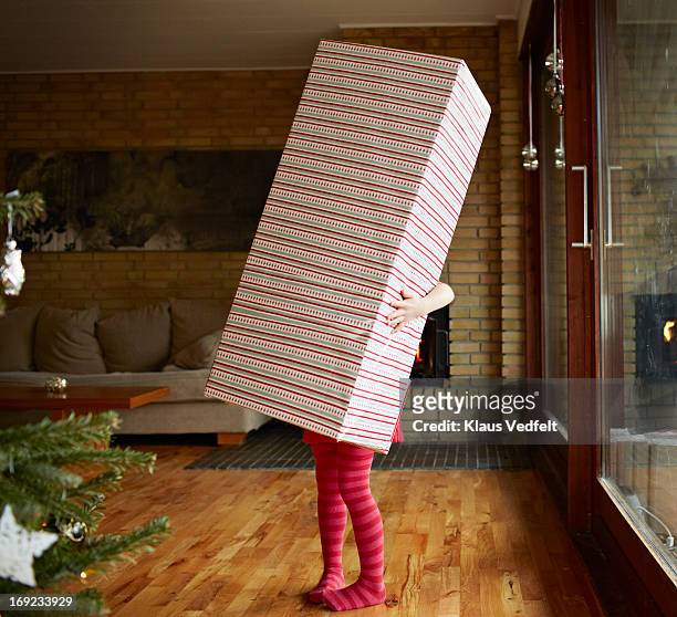 little girl holding huge present - wrapping paper stock-fotos und bilder