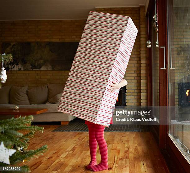 little girl holding huge present - funny gifts photos et images de collection