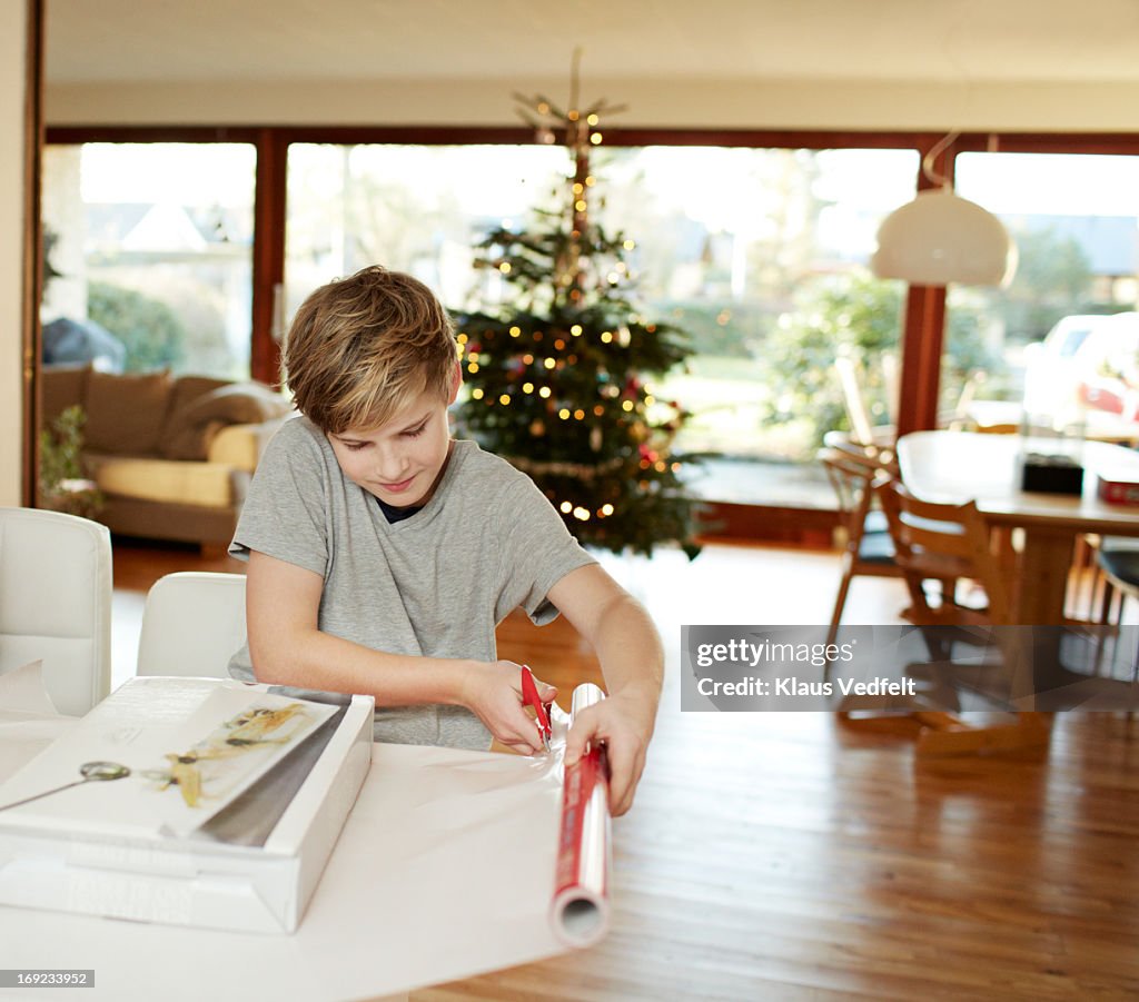 Boy wrapping up christmas present