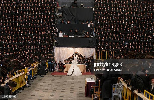 Tens of thousands of Ultra-Orthodox Jews of the Belz Hasidic Dynasty watch the the bride Hannah Batya Penet dances with her relative during the...