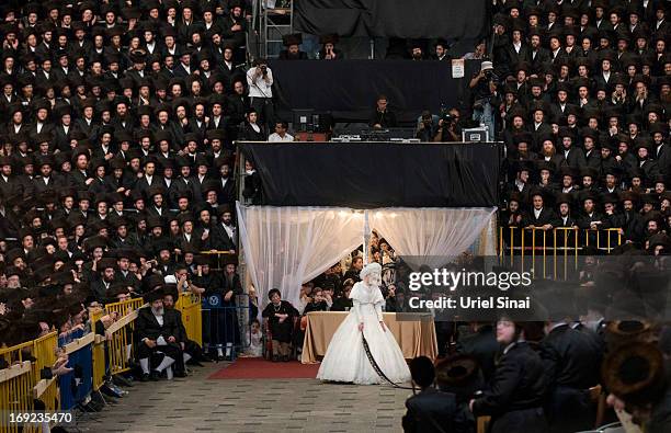 Tens of thousands of Ultra-Orthodox Jews of the Belz Hasidic Dynasty watch the the bride Hannah Batya Penet dances with her relative during the...