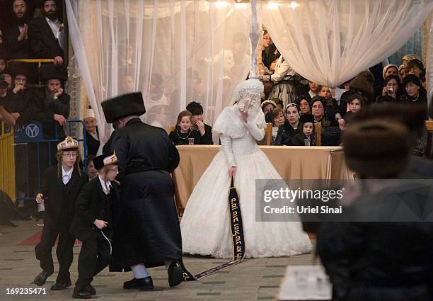 Tens of thousands of Ultra-Orthodox Jews of the Belz Hasidic Dynasty watch the the bride Hannah Batya Penet dances with her relative during the...