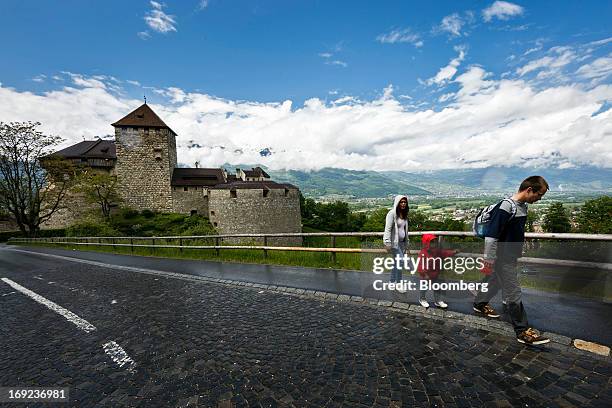 Pedestrians walk along a sidewalk near Vaduz castle, the official residence of Prince Alois of Liechtenstein, in Vaduz, Liechtenstein, on Monday, May...