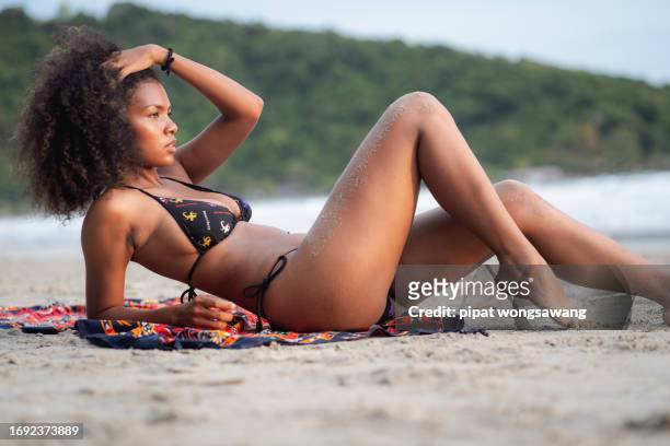 african american woman in bikini lounging on the beach - asian swimsuit models stock pictures, royalty-free photos & images