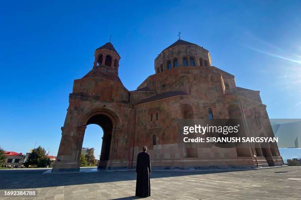 Priest stands in front of a church in Stepanakert on September 27, 2023. Armenia said on September 27 that 42,500 refugees have arrived from...