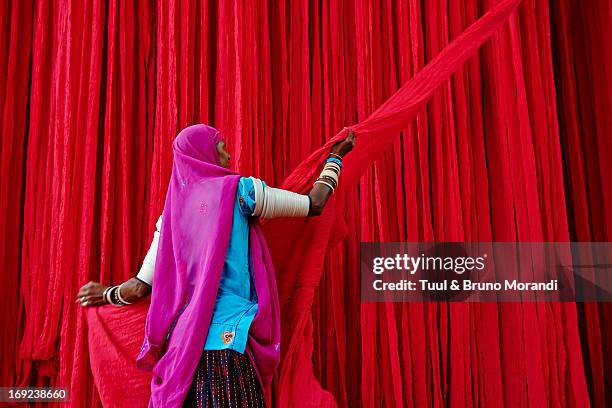 india, rajasthan, sari factory. - woman in red sari stock-fotos und bilder