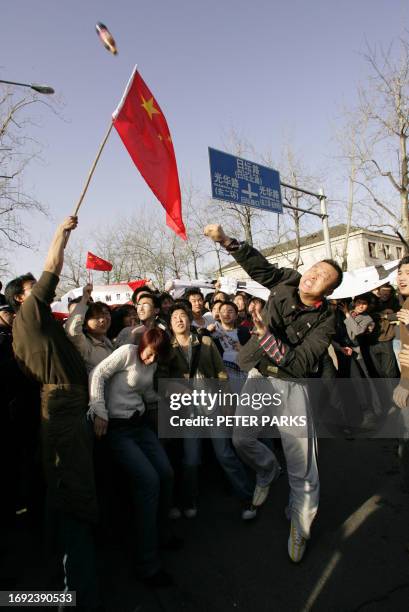 Demonstrator throws a bottle at the Japanese embassy in Beijing as thousands gather outside to protest Japan's handling of its wartime past and...