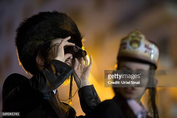 Man looks through his binoculars as tens of thousands of Ultra-Orthodox Jews of the Belz Hasidic Dynasty take part in the wedding ceremony of Rabbi...