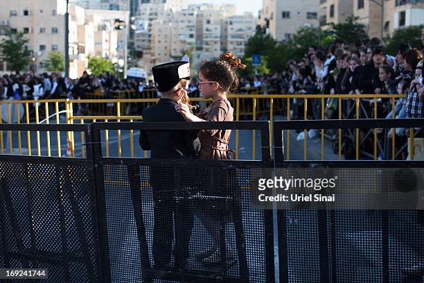 Boy and a girl hug as tens of thousands of Ultra-Orthodox Jews of the Belz Hasidic Dynasty take part in the wedding ceremony of Rabbi Shalom Rokach,...