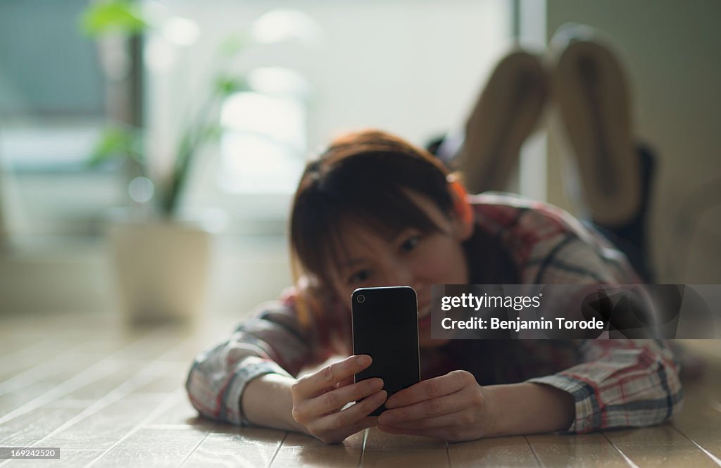 Girl Taking Picture with Smartphone on Floor