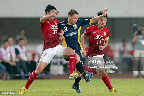 Daniel McBreen of Central Coast Mariners challenges Zhang Xuri and Zheng Zhi of Guangzhou Evergrande during the AFC Champions League knockout round...