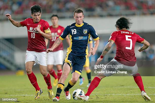 Mitchell Duke of Central Coast challenges Zheng Zhi and Zhang Linpeng of Guangzhou Evergrande during the AFC Champions League knockout round match...