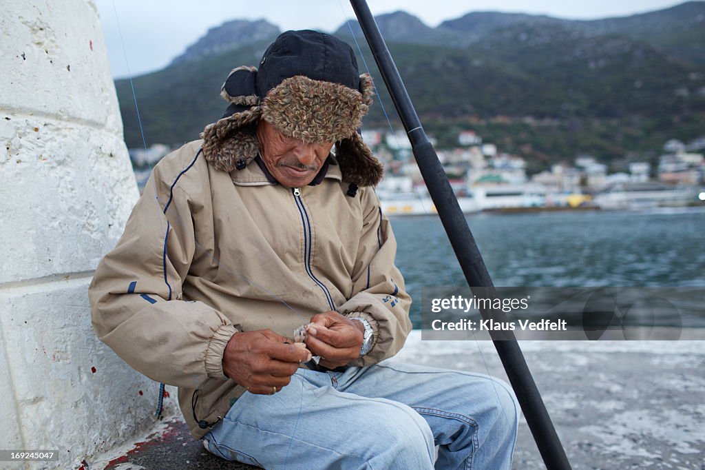 Old fisherman preparing bait