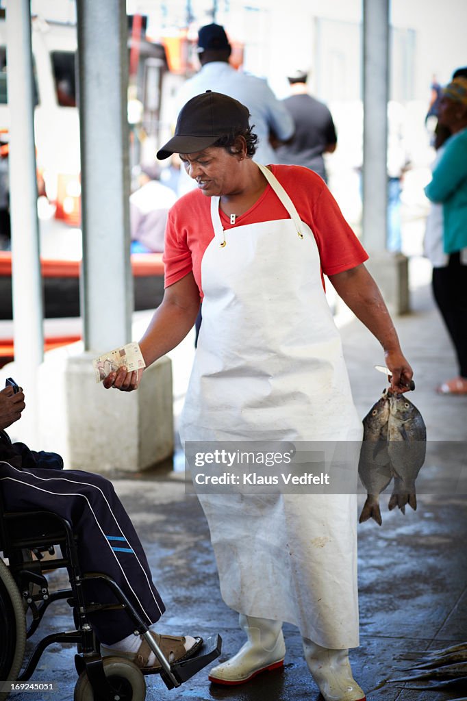 Fishworker selling fish at market