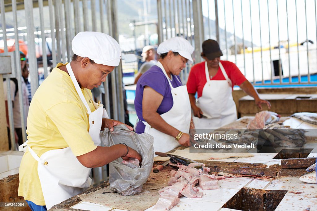Woman packing fish in bag at fish market