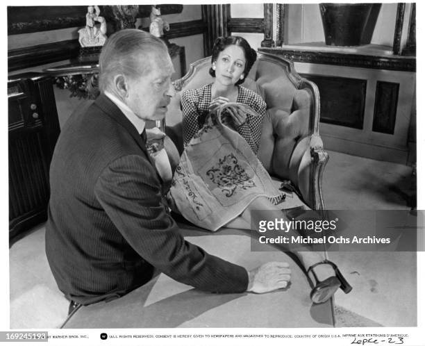 Milton Berle sits with Anjanette Comer in a scene from the film 'Lepke', 1975.