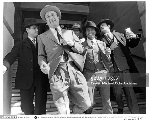 Vic Tayback exits the courtroom with his entourage in a scene from the film 'Lepke', 1975.