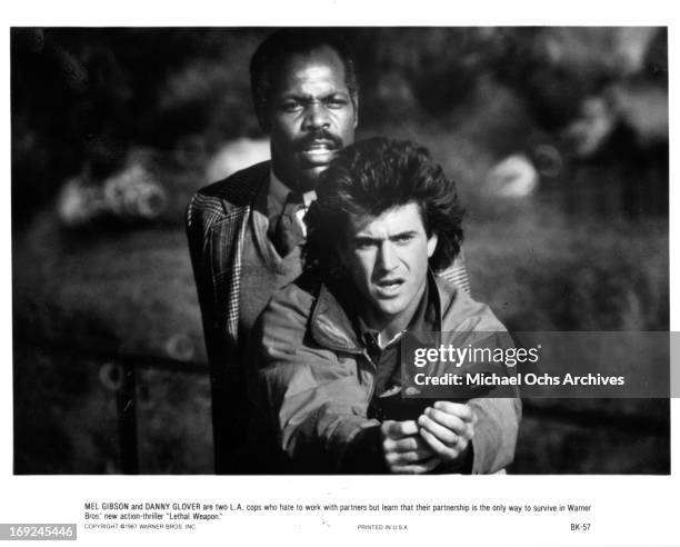 Danny Glover stands behind Mel Gibson in a scene from the film 'Lethal Weapon', 1987.