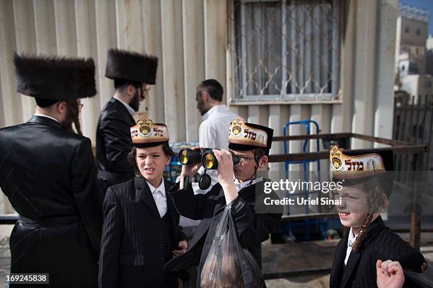 Boy looks through binoculars as tens of thousands of Ultra-Orthodox Jews attend the wedding of Rabbi Shalom Rokeach, the grandson of the leader of...