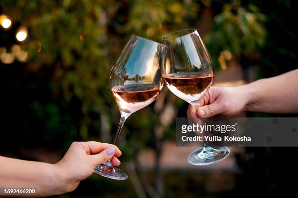 couple toasting wine glasses - roses stockfoto's en -beelden