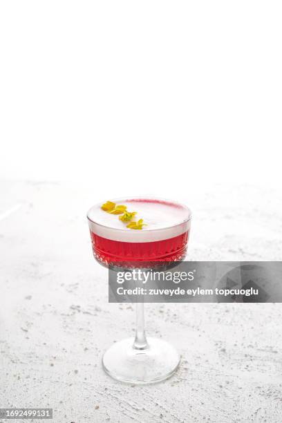 pink cocktail or mocktail fashionable crystal high glass for dessert and champagne yellow blossoms inside on the white background - ice flower stock pictures, royalty-free photos & images