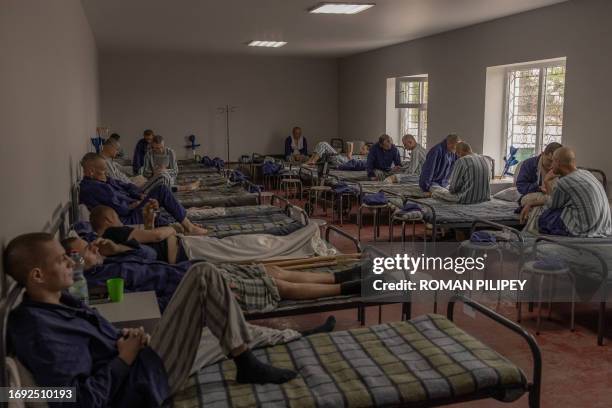 Injured Russian prisoners of war sit and lie on their beds at a camp for Russian POWs in western Ukraine on September 19 amid the Russian invasion of...
